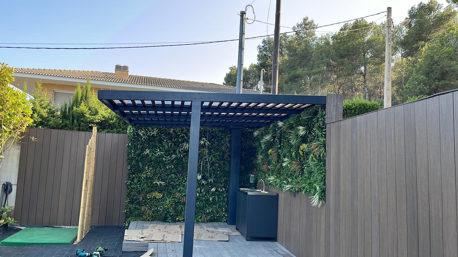Pérgola instalada con paneles vegetales y fregadero Diseño de jardín con piscina y césped en Sitges Pérgola instalada con paneles vegetales y fregadero
