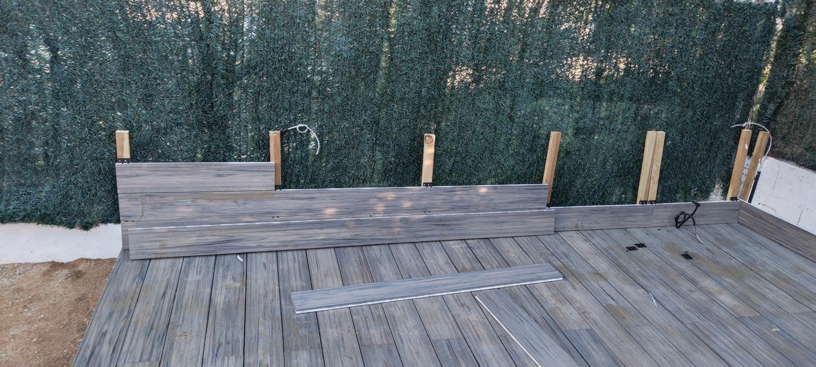 Colocación de tablas y revestimiento perimetral de la tarima Jardín con piscina, tarima y pérgola en Castelldefels Colocación de tablas y revestimiento perimetral de la tarima