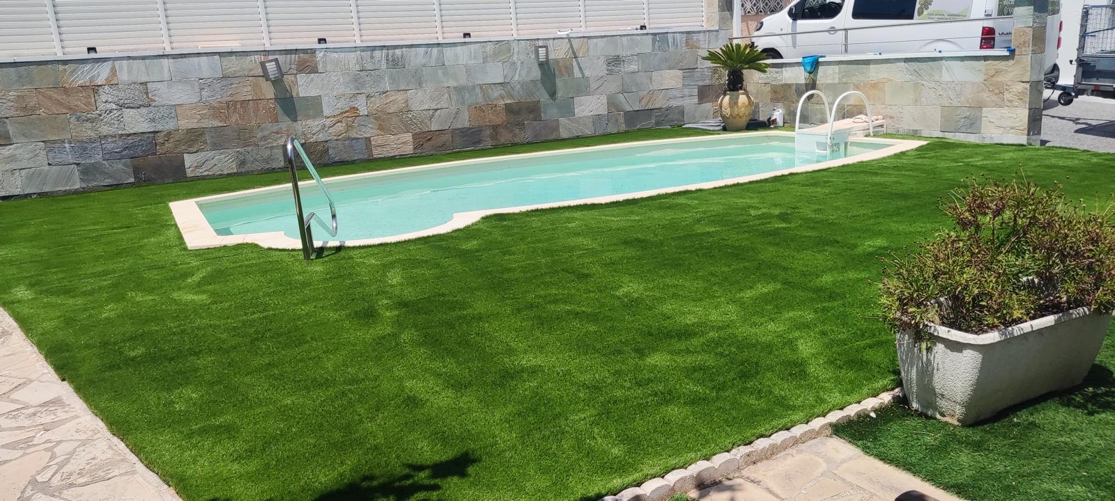 Césped artificial instalado alrededor de la piscina en Castelldefels Jardín con piscina, tarima y pérgola en Castelldefels Césped artificial instalado alrededor de la piscina en Castelldefels