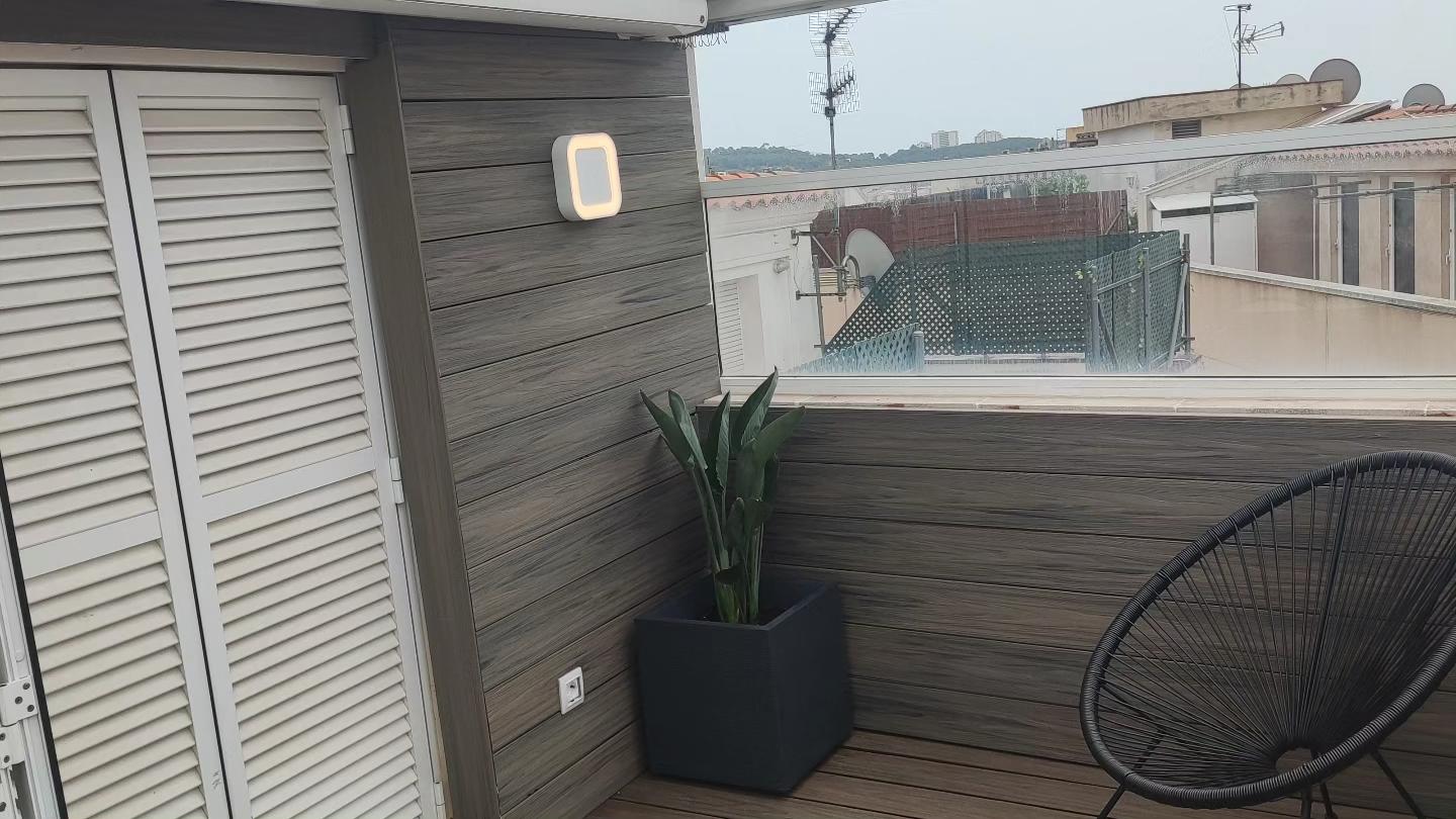 Planta en maceta e iluminación junto al revestimiento de madera de la terraza Tarima de madera y diseño de terraza en Cubelles Planta en maceta e iluminación junto al revestimiento de madera de la terraza
