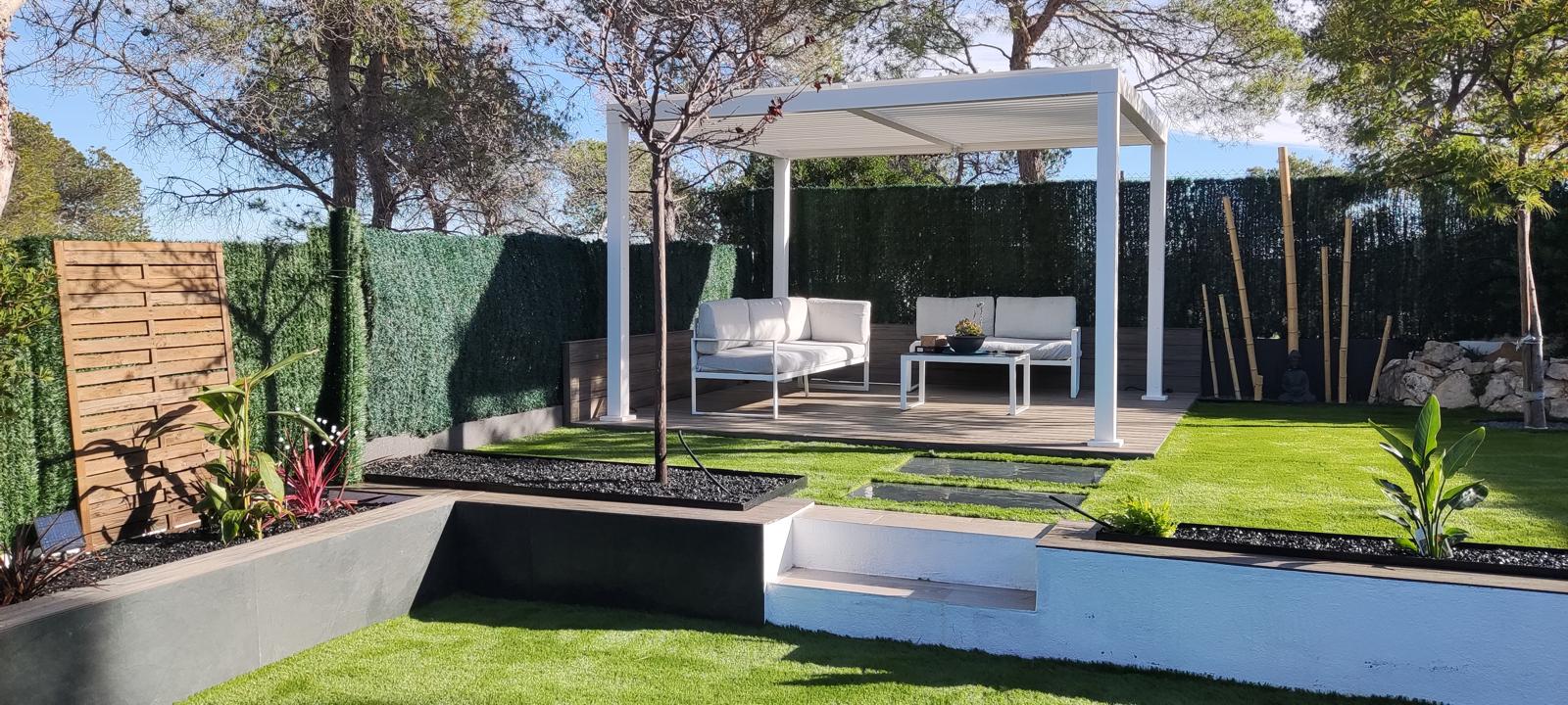 Jardín en Castelldefels con césped artificial, tarima, pérgola y jardineras